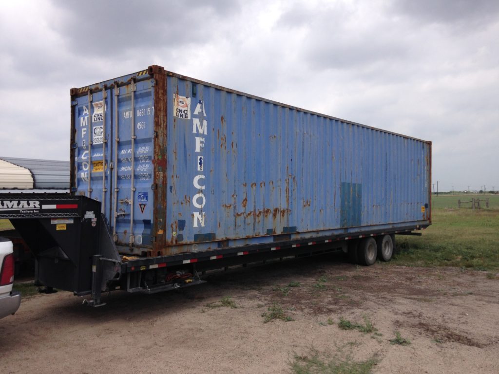 A 40-foot shipping container on a delivery trailer at a customer property